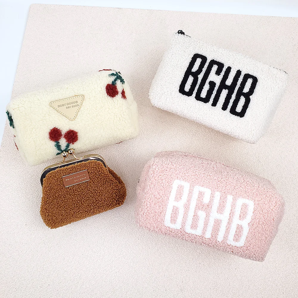 Four teddy sherpa pouches on a light background: cream cherry-print barrel bag, white and blush-pink pouches embroidered BGHB, small tan kiss-lock coin purse with gold frame
