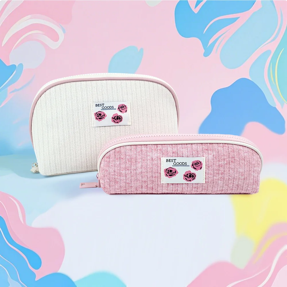 Two ribbed knit cosmetic pouches in cream and blush pink with BEST GOODS rose-print labels, set against a pastel abstract background