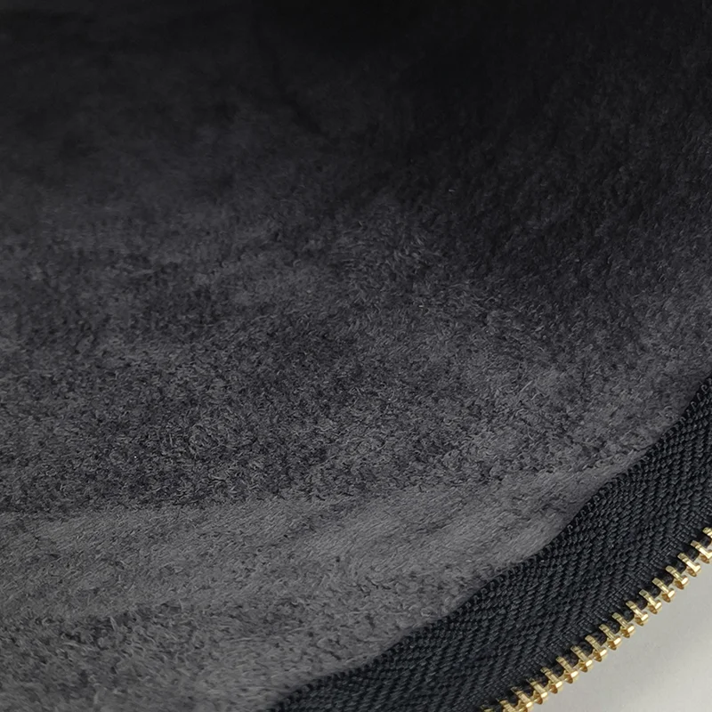 Close-up of charcoal plush-lined bag interior showing black woven zipper tape and gold metal zipper teeth