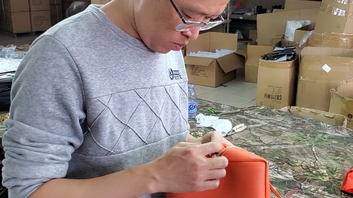 Quality inspector checking a finished cosmetic bag