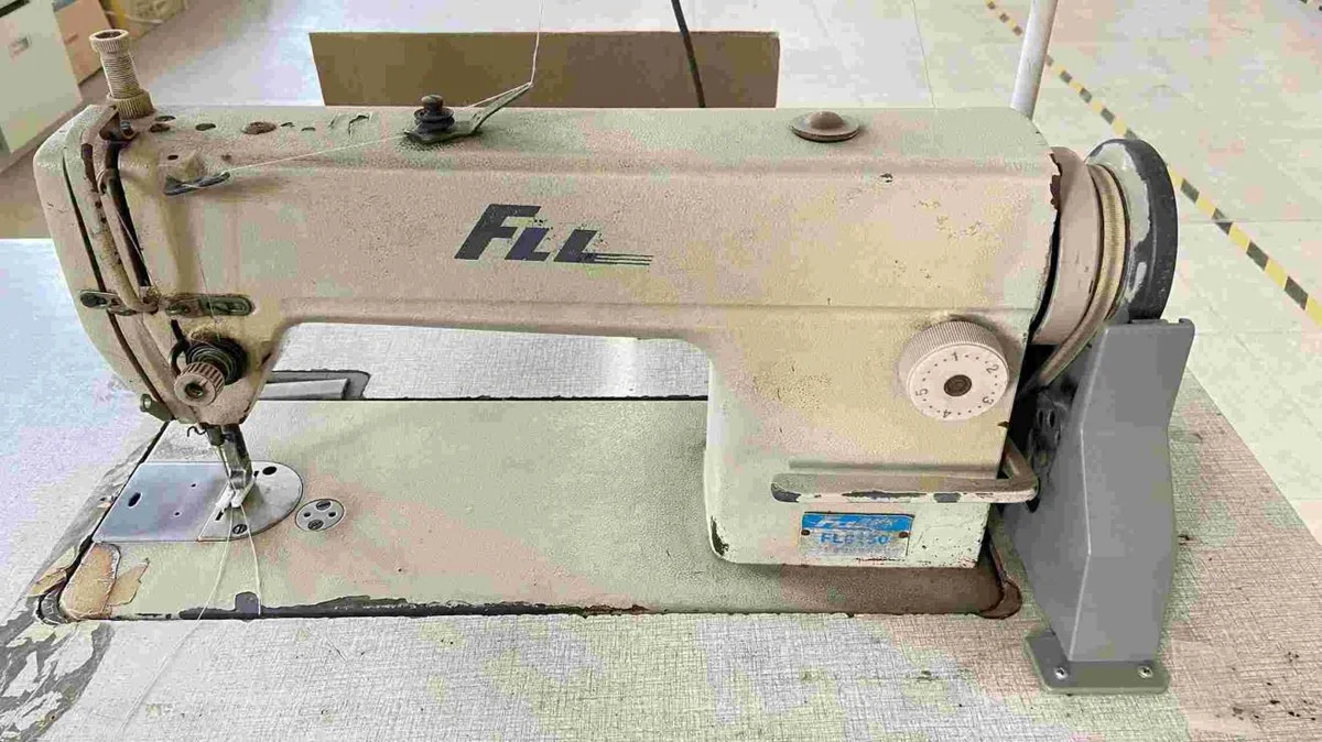 Industrial sewing machine at a production workstation