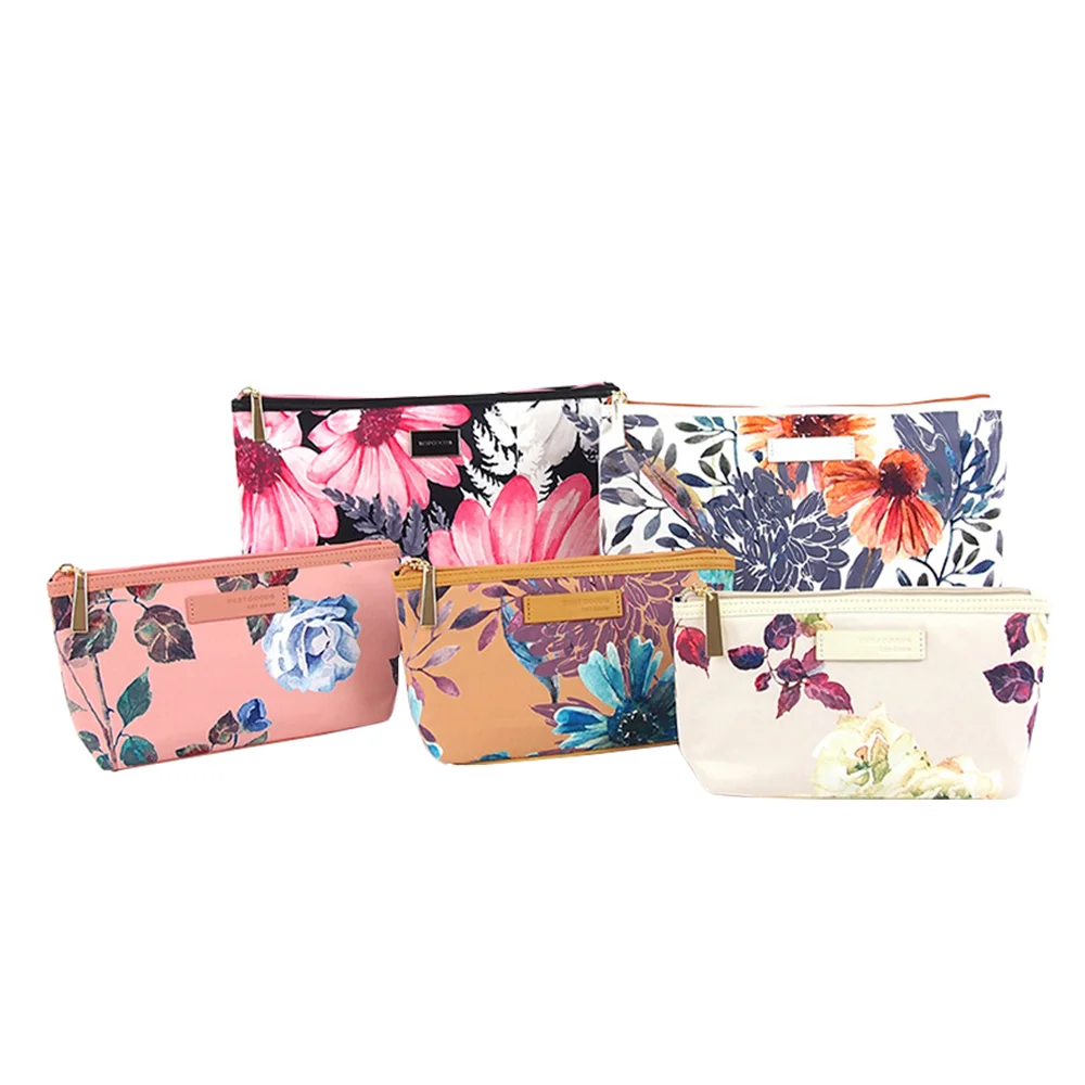 Five floral-print zip-top cosmetic pouches in assorted colorways arranged on a pure white background