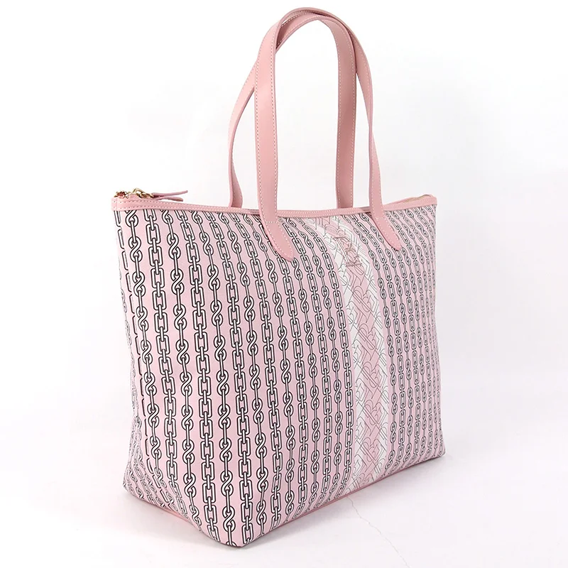 Blush-pink zip-top tote bag with black chain-link print and tonal center panel, pink leather shoulder straps, gold zipper, on white background