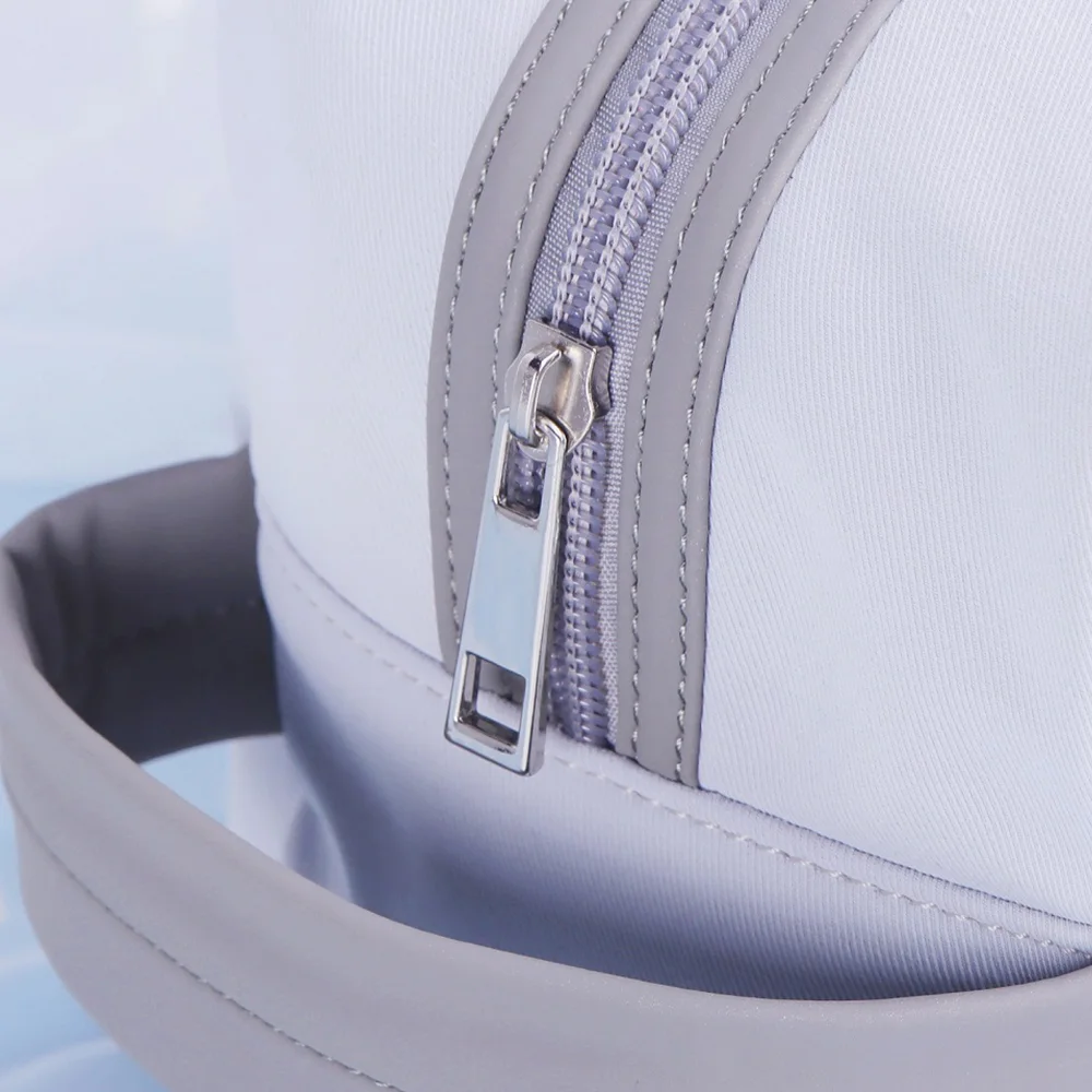 Close-up of light gray vanity case showing curved zipper with silver metal pull and gray PU trim, loop handle visible