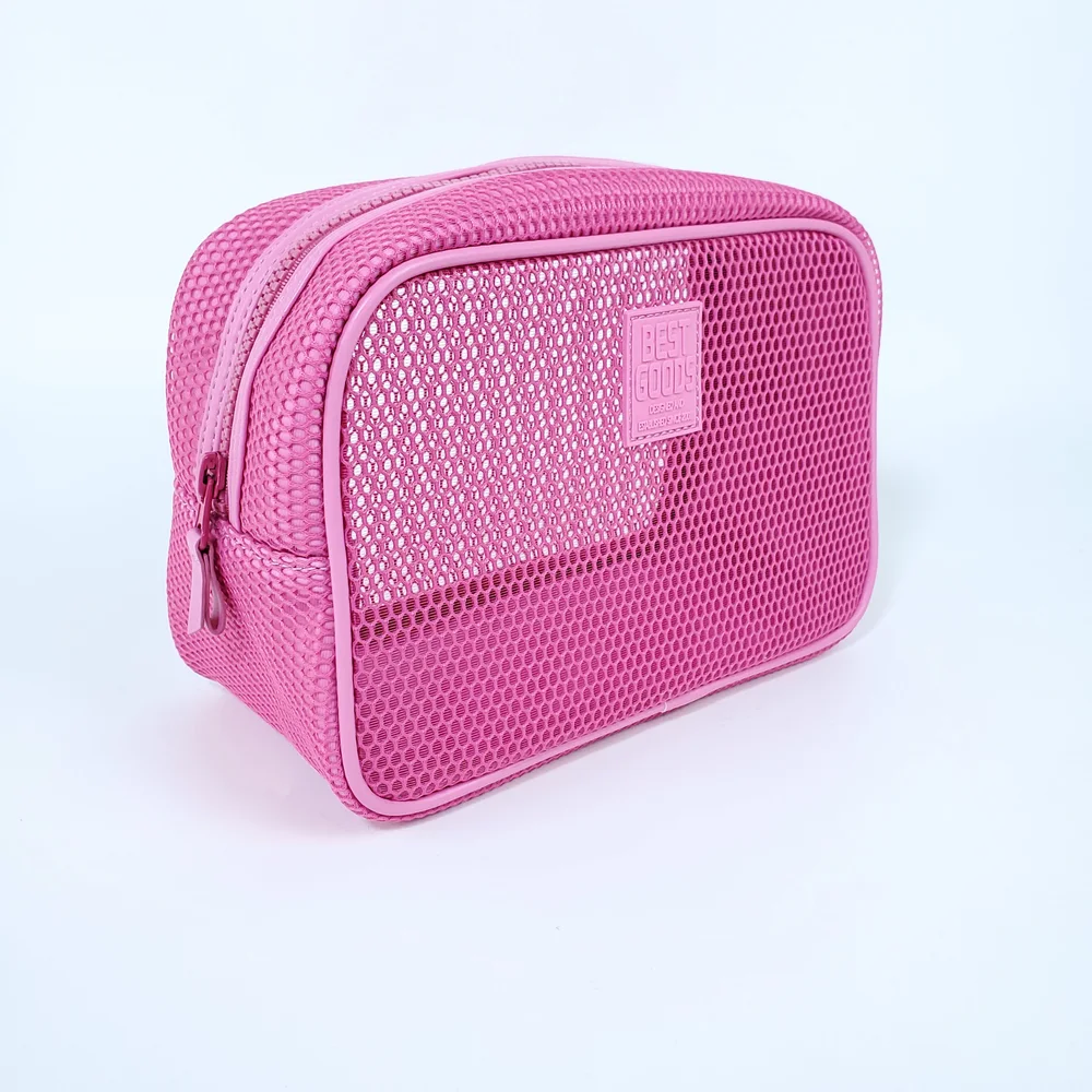Hot-pink mesh zip-top cosmetic pouch with rubber BEST GOODS logo patch, three-quarter view on white background